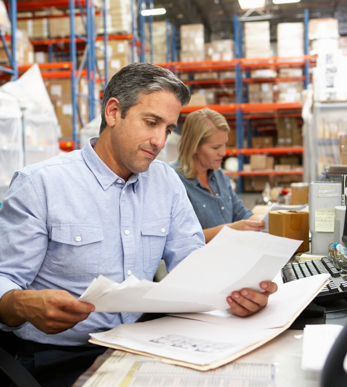 Business Colleagues Working At Desk In Warehouse